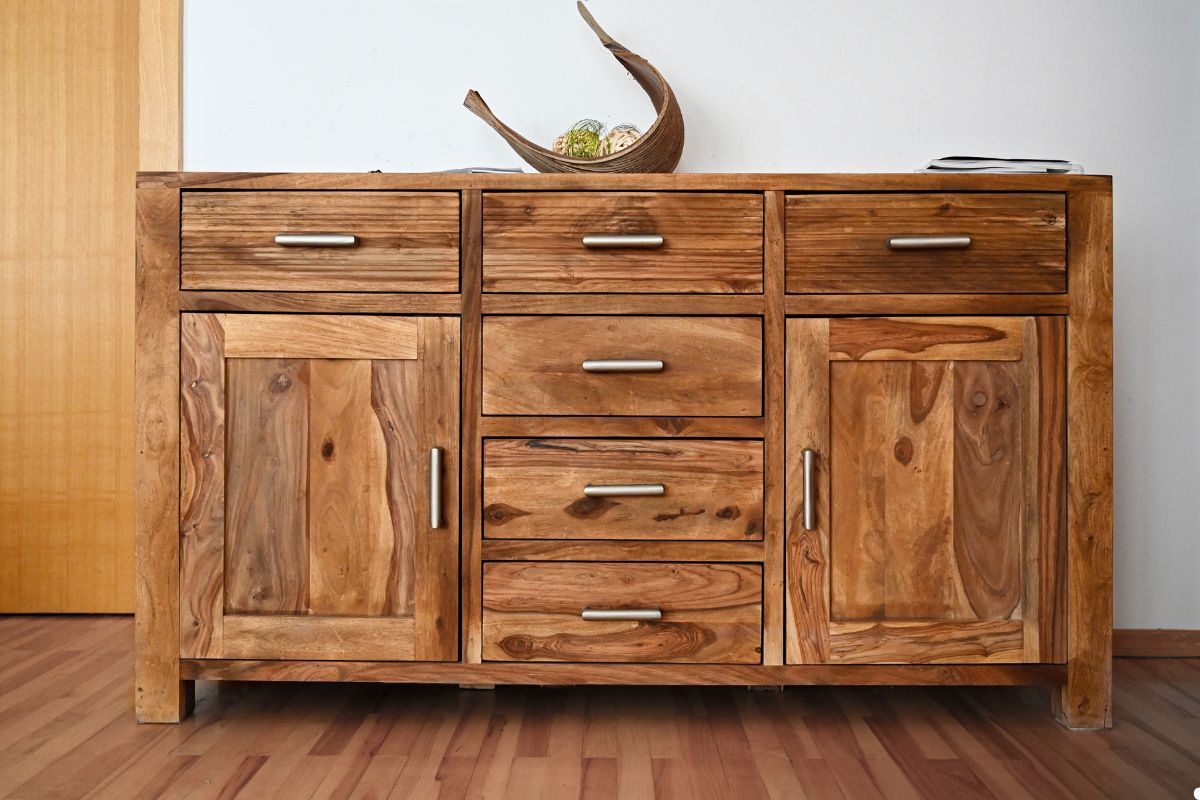 Wooden sideboard featuring four drawers and a single door, showcasing a natural finish and simple design.